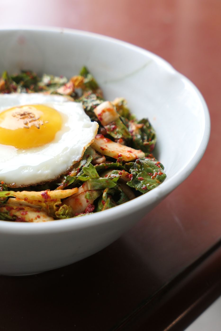 A bowl of barley rice topped with a fried egg