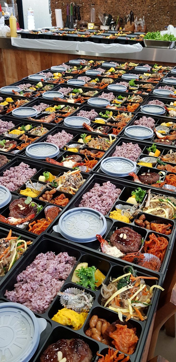 Dozens of identical bento boxes prepared in rows