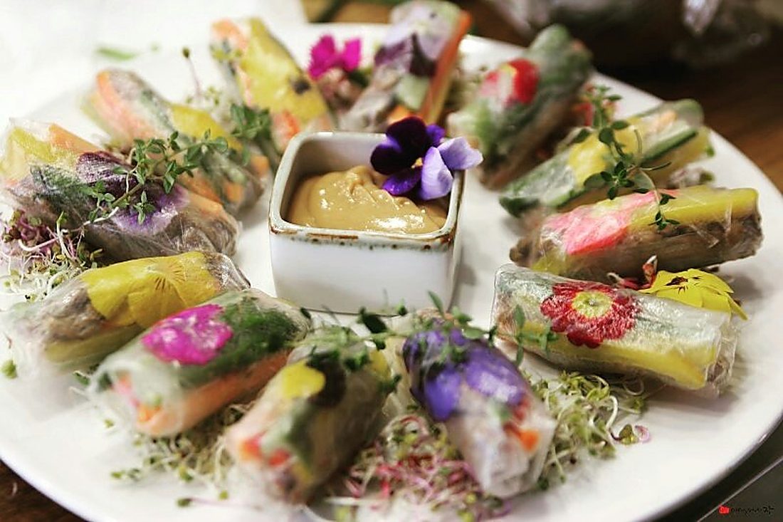 Fresh rice paper rolls with edible flowers and dipping sauce