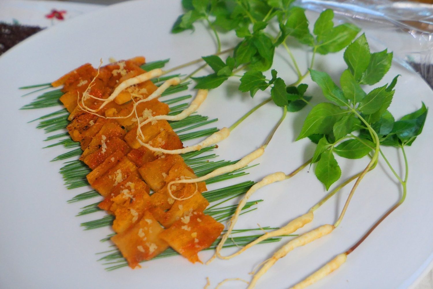 Glazed skewers plated in a row with herbs